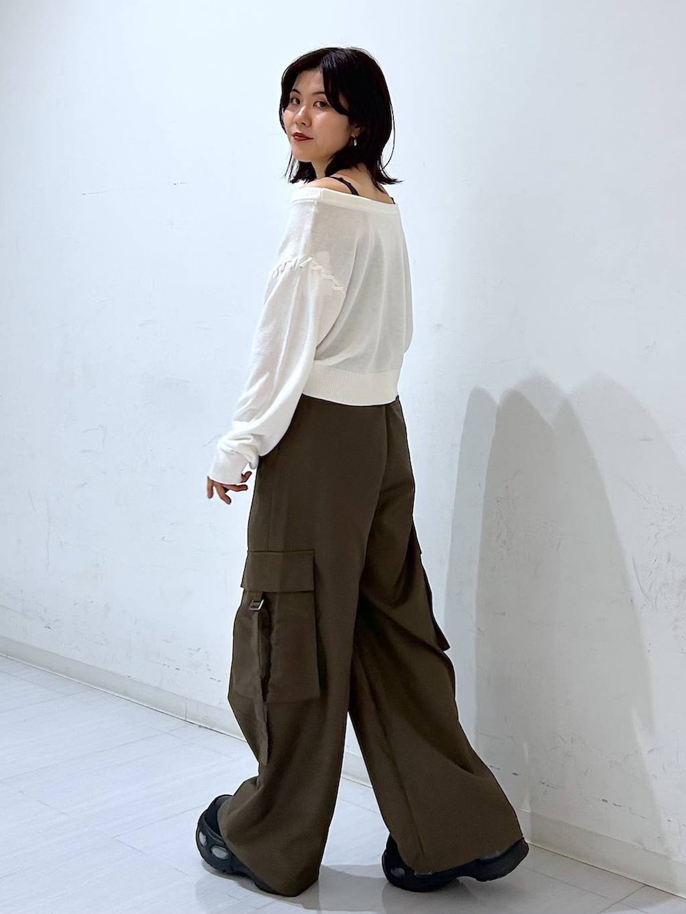 ホワイト系のTシャツ/カットソー、ブラウン系のスラックス、ブラック系のベルトを着用したレディースの秋コーディネートの4枚目の写真