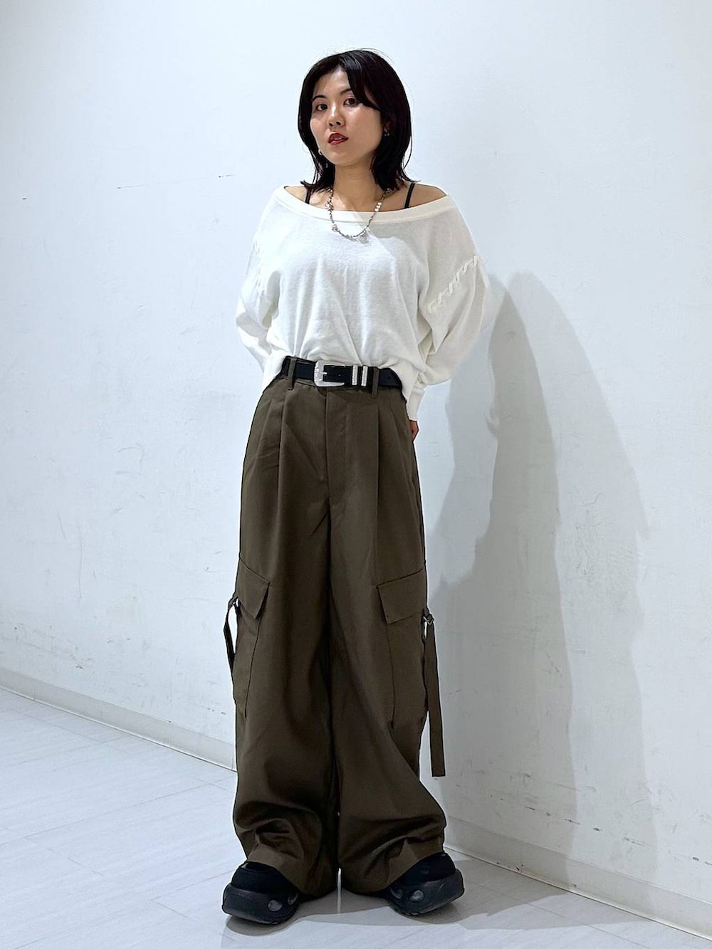 ホワイト系のTシャツ/カットソー、ブラウン系のスラックス、ブラック系のベルトを着用したレディースの秋コーディネートの2枚目の写真