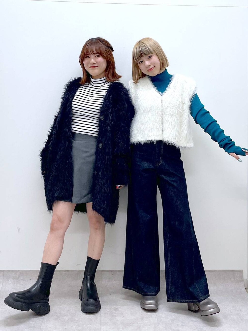 ブルー系のデニムパンツ、ブラック系のブーツ、ブラック系のカーディガン/ボレロを着用したレディースの秋コーディネートの2枚目の写真