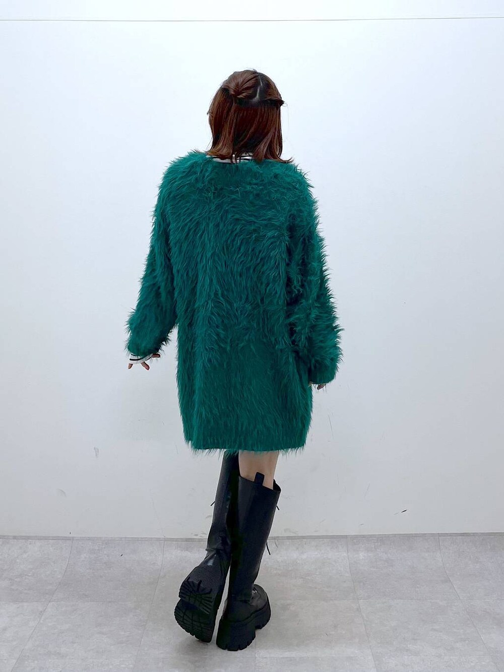 グリーン系のカーディガン/ボレロ、ブラック系のブーツ、ブラック系のその他パンツを着用したレディースの秋コーディネートの5枚目の写真