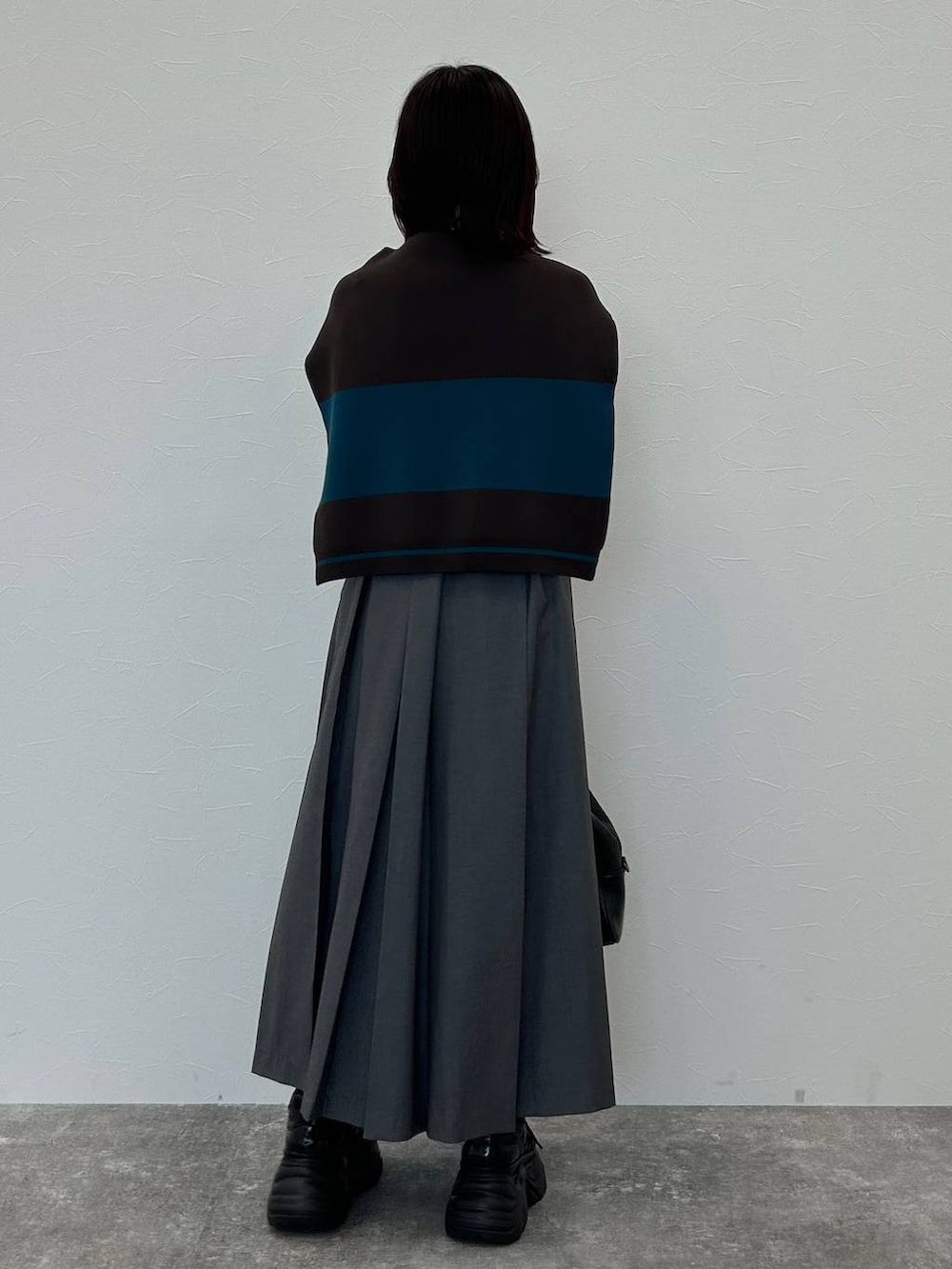 ブラック系のスニーカー、グレー系のボストンバッグ、グレー系のスカートを着用したレディースの秋コーディネートの6枚目の写真