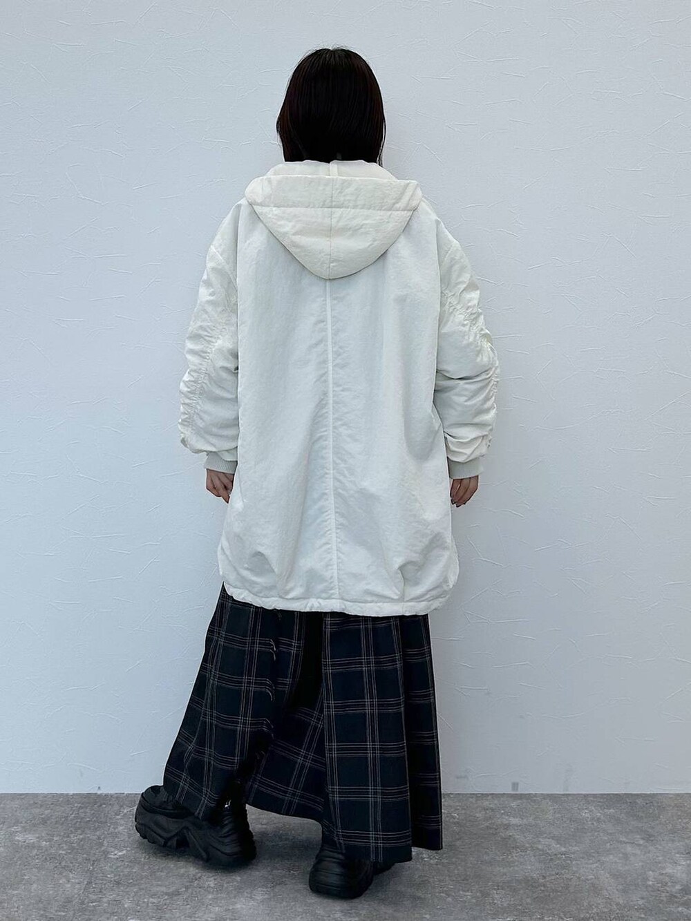 ブラック系のスニーカー、ホワイト系のブルゾン、ブルー系のニット/セーターを着用したレディースの秋コーディネートの6枚目の写真