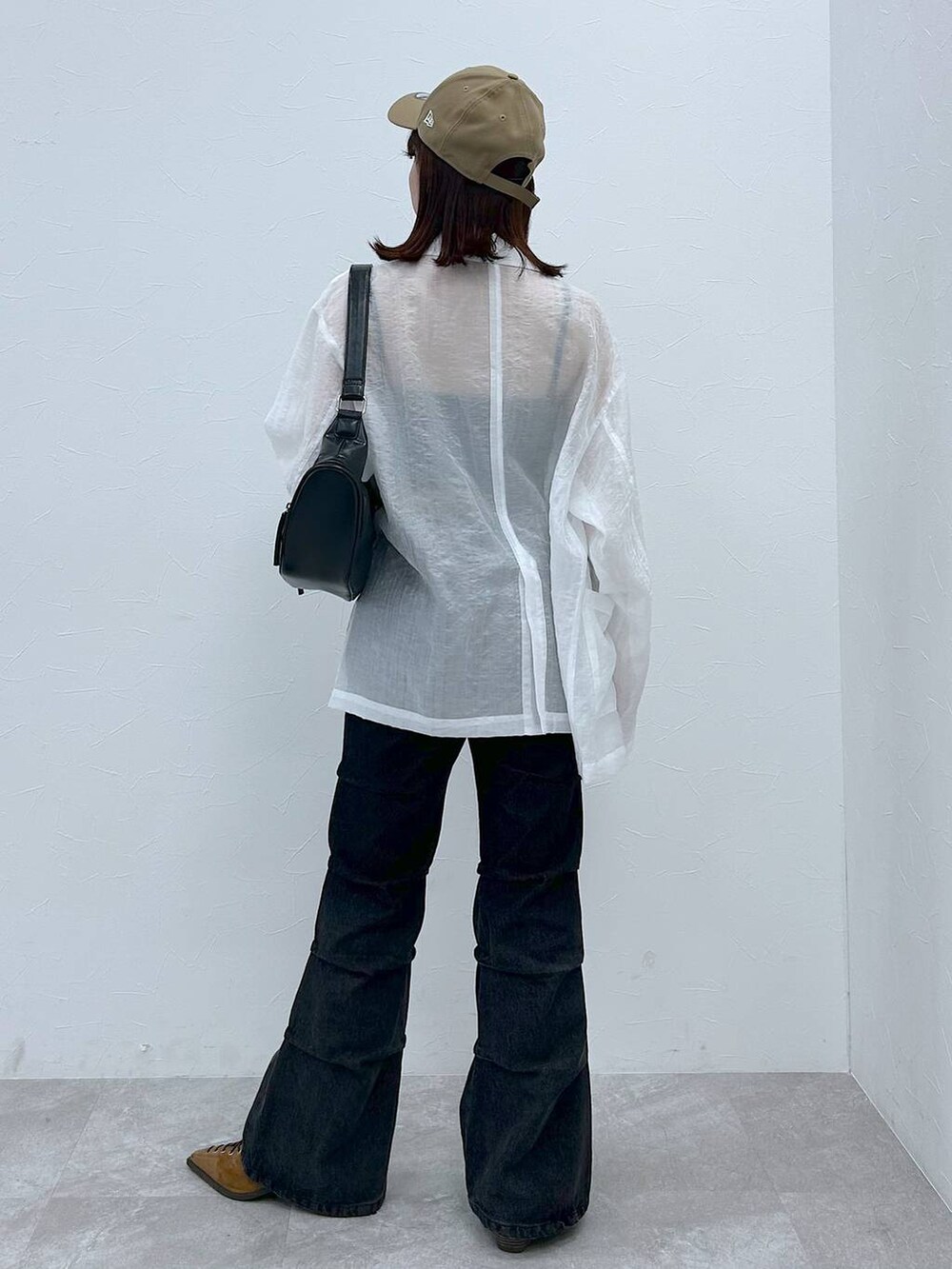 ブラウン系のパンプス、ブラック系のショルダーバッグ、ブラック系のデニムパンツを着用したレディースの春コーディネートの5枚目の写真