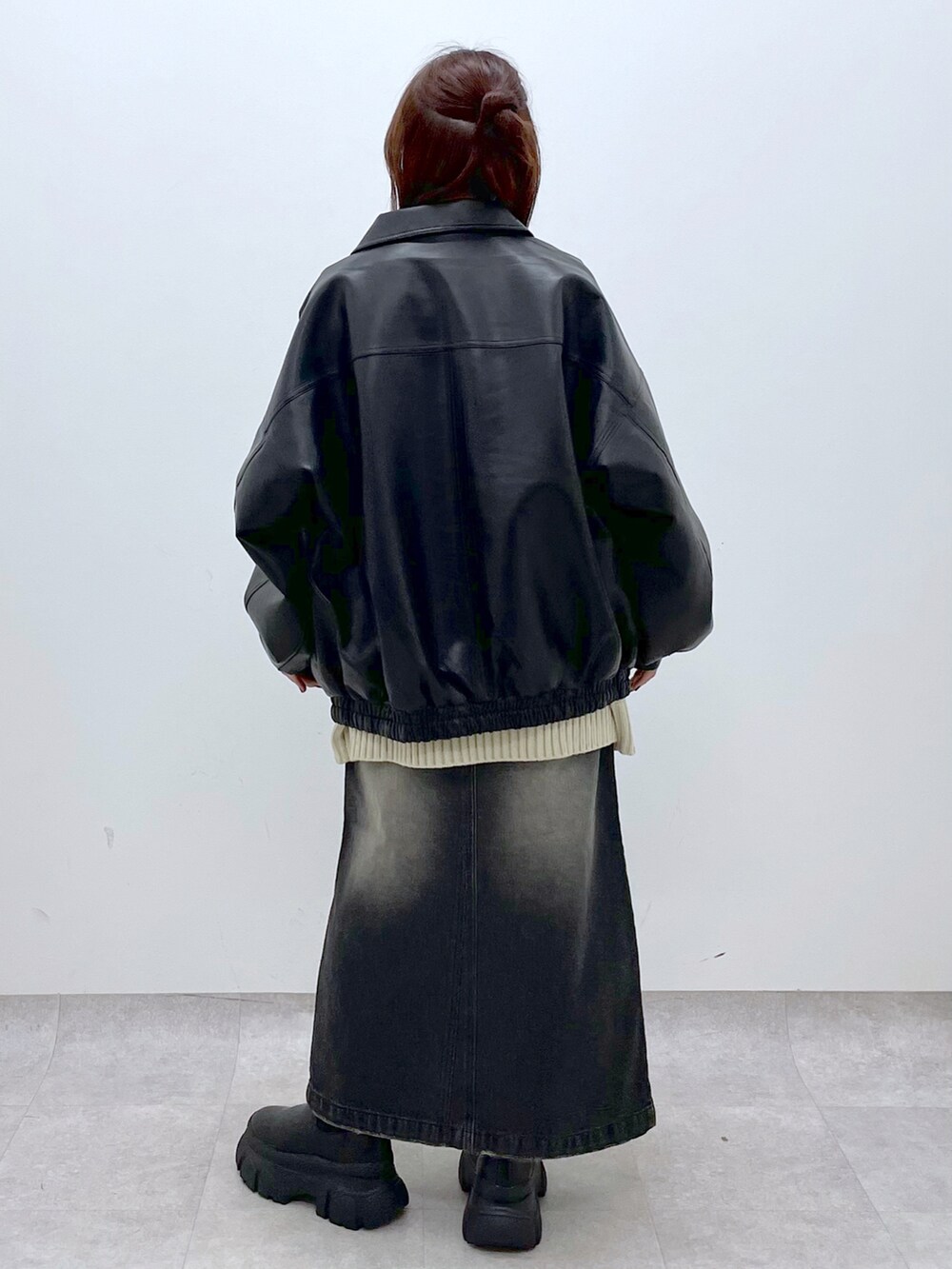 ブラック系のブーツ、ブラック系のスカート、ブラック系のブルゾンを着用したレディースの秋コーディネートの5枚目の写真