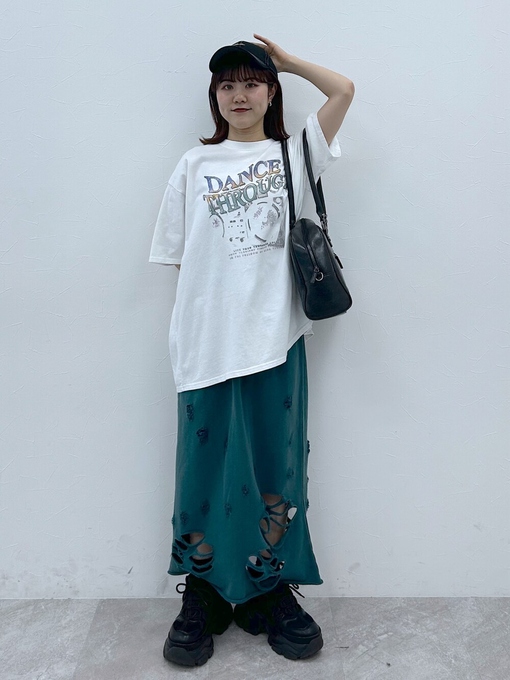 ブラック系のボストンバッグ、ブラック系のスニーカー、ホワイト系のTシャツ/カットソーを着用したレディースの春コーディネートの3枚目の写真