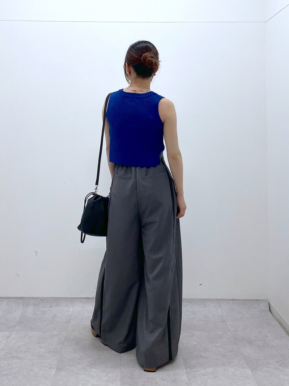 ブルー系のタンクトップ、グレー系のスラックス、ブラック系のローファーを着用したレディースの夏コーディネートの4枚目の写真