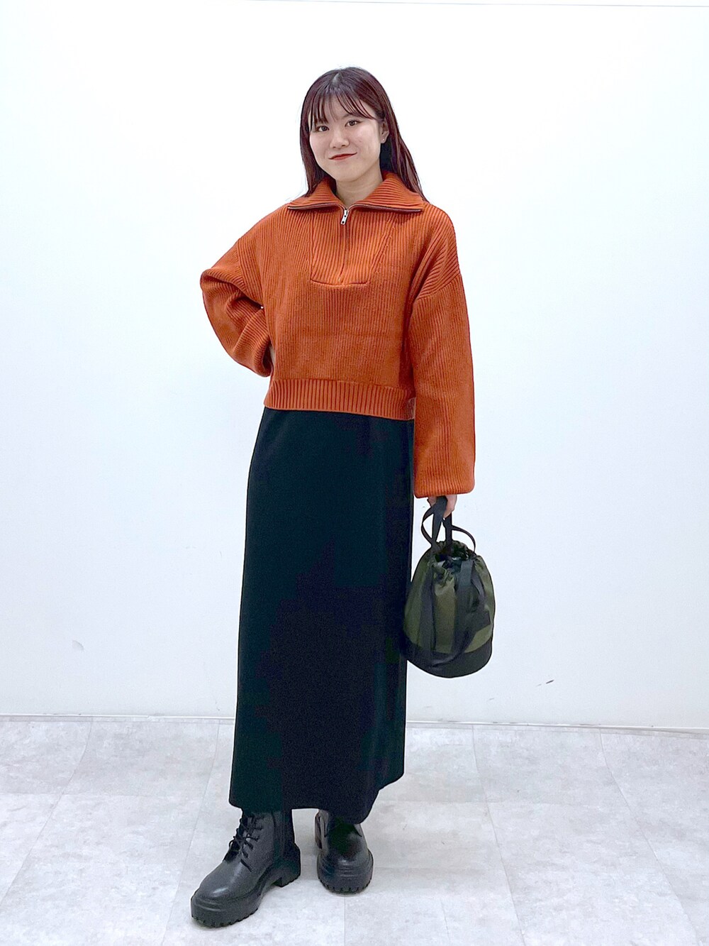 ブラック系のブーツ、ブラック系のワンピース、オレンジ系のニット/セーターを着用したレディースの秋コーディネートの3枚目の写真