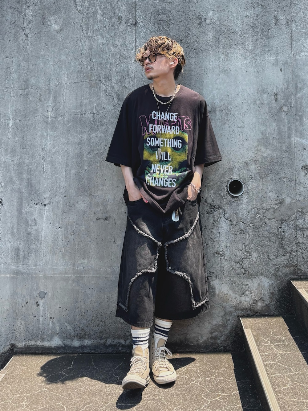 ブラック系のデニムパンツ、ベージュ系のスニーカー、ブラック系のTシャツ/カットソーを着用したメンズの夏コーディネートの2枚目の写真