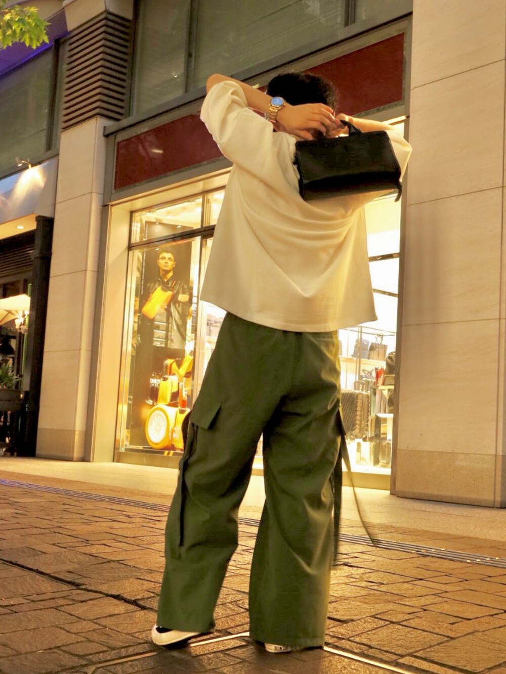 ホワイト系のTシャツ/カットソー、グリーン系のスラックスを着用したメンズの夏コーディネートの2枚目の写真