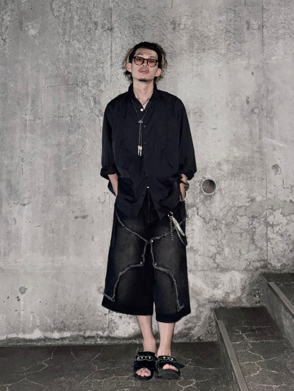 ブラック系のデニムパンツ、ブラック系のシャツ/ブラウス、ブラック系のサンダルを着用したメンズの夏コーディネートの2枚目の写真