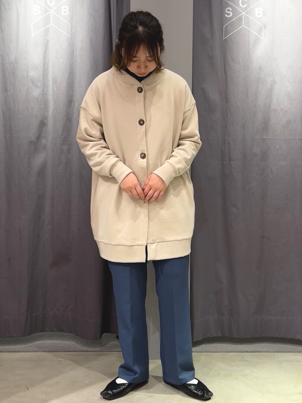 ホワイト系のカーディガン/ボレロ、ブルー系のスラックスを着用したレディースの冬コーディネートの3枚目の写真