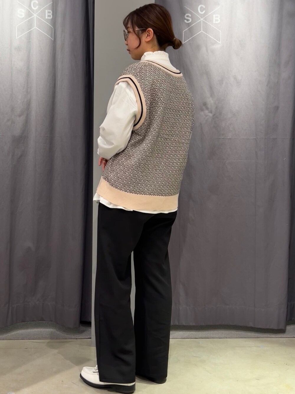 ホワイト系のシャツ/ブラウス、ベージュ系のベスト、ブラック系のスラックスを着用したレディースの春コーディネートの4枚目の写真