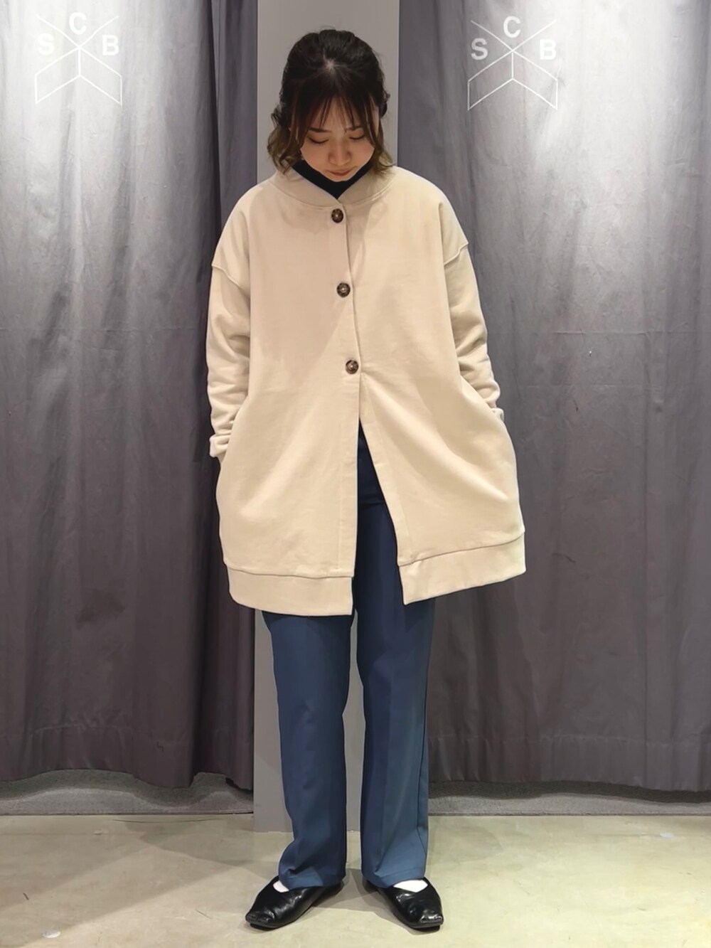 ホワイト系のカーディガン/ボレロ、ブルー系のスラックスを着用したレディースの冬コーディネートの2枚目の写真