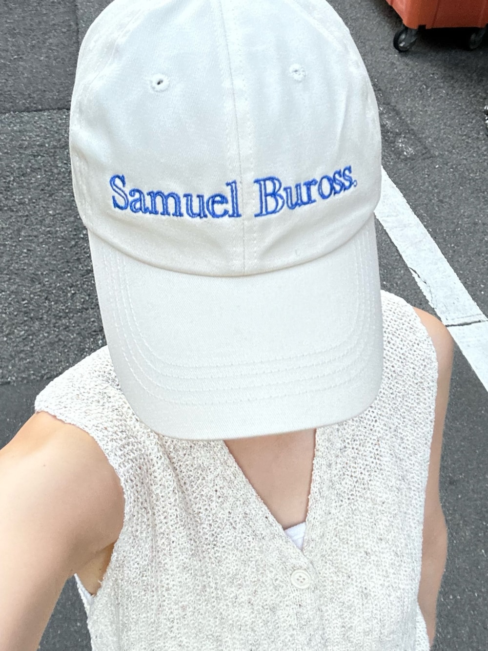 ベージュ系のベスト、ブルー系のデニムパンツ、ホワイト系のサンダルを着用したレディースの夏コーディネートの2枚目の写真