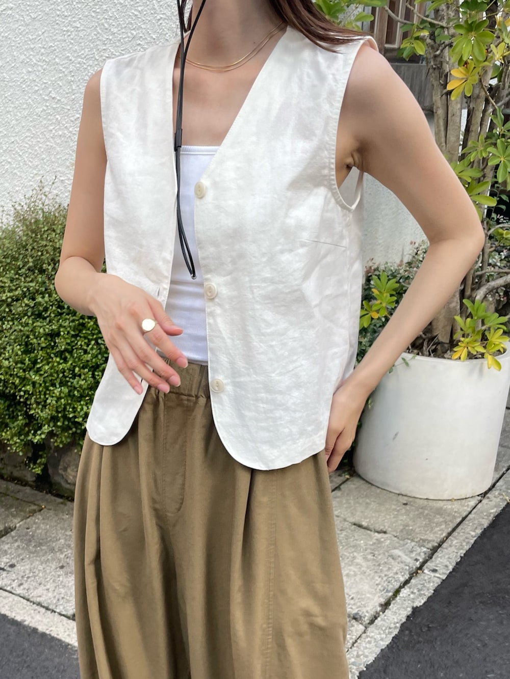 ホワイト系のキャミソール、ホワイト系のベスト、ブラウン系のその他パンツを着用したレディースの夏コーディネートの2枚目の写真