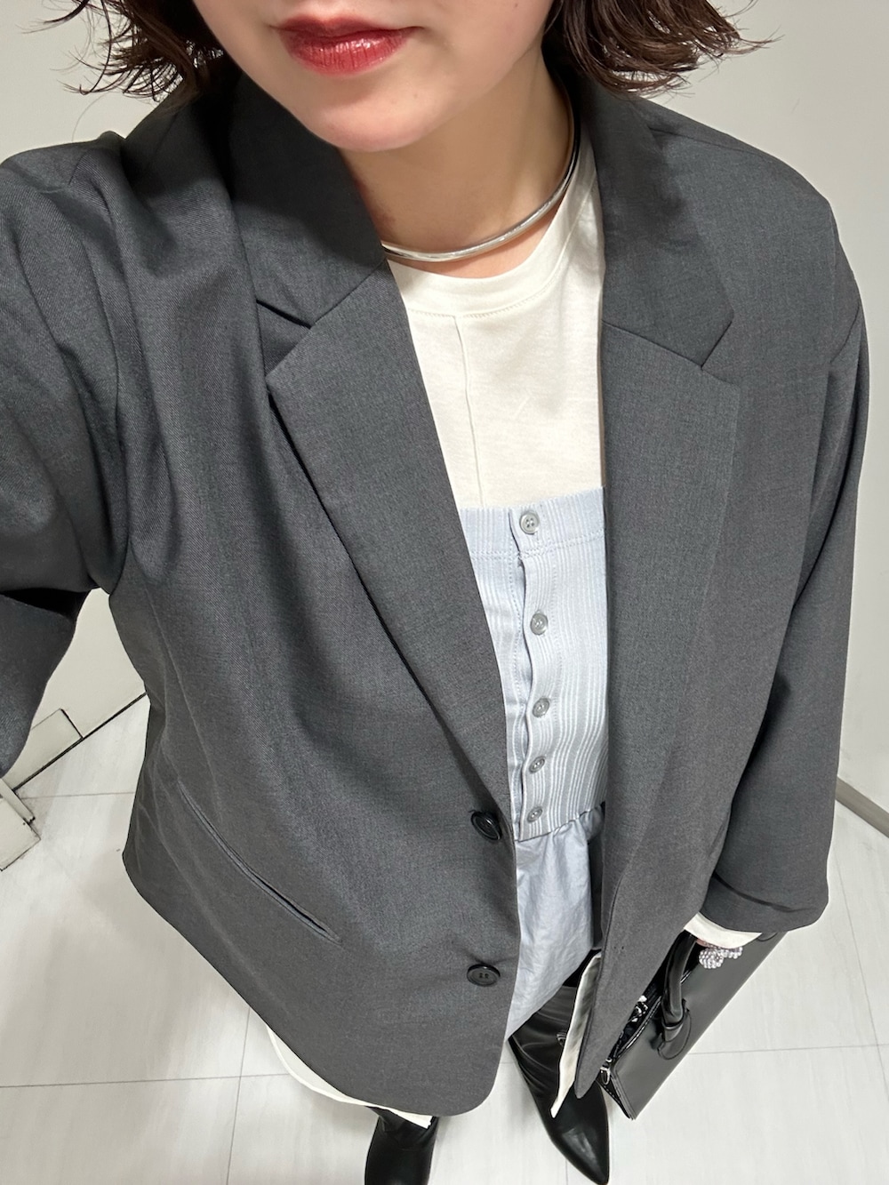 ホワイト系のTシャツ/カットソー、グレー系のその他アウター、ブラック系のその他パンツを着用したレディースの冬コーディネートの4枚目の写真