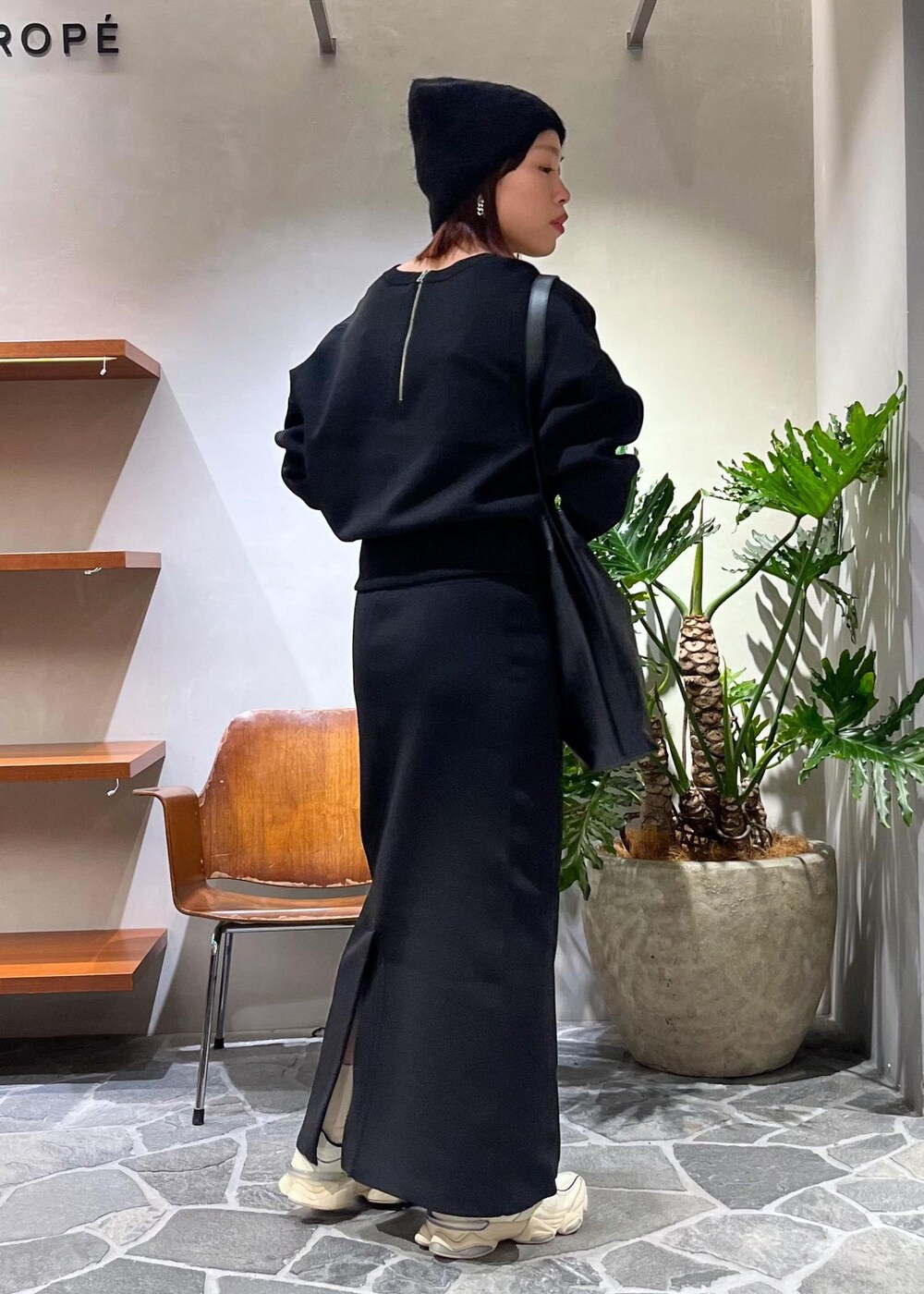 ブラック系のTシャツ/カットソー、ブラック系のスカート、ブラック系のトートバッグを着用したレディースの秋コーディネートの3枚目の写真