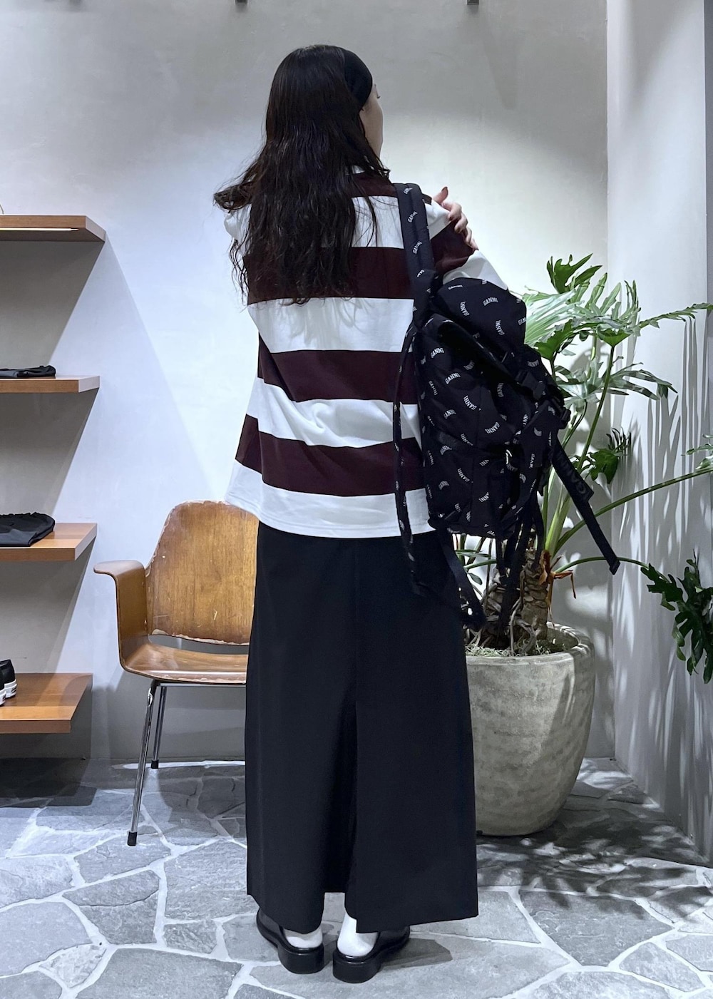 ブラック系のスカート、ブラック系のサンダル、ブラック系のバックパック/リュックを着用したレディースの春コーディネートの7枚目の写真