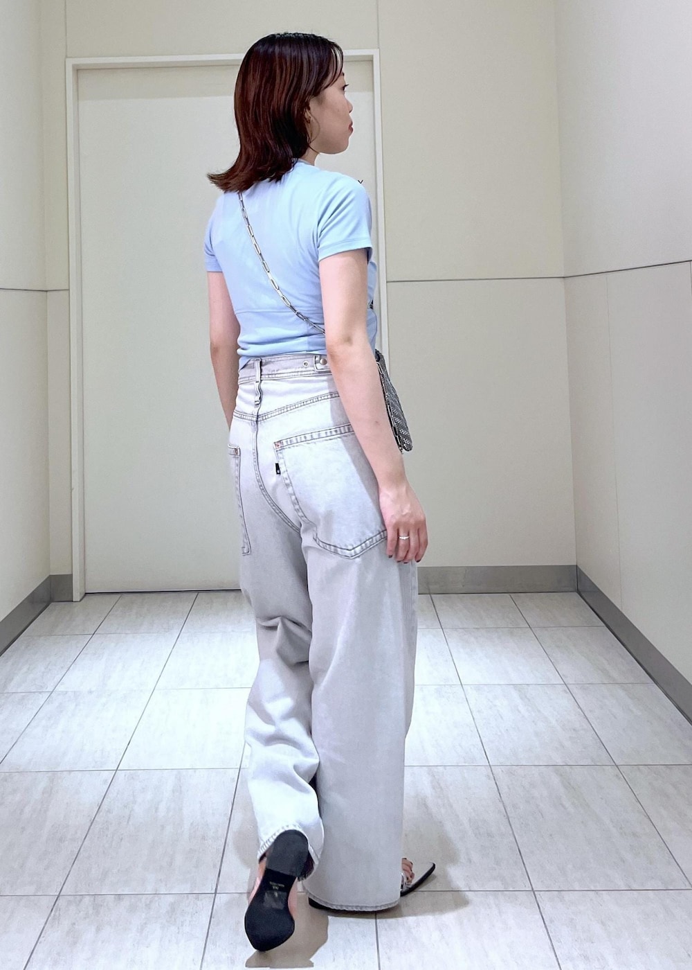 シルバー系のサンダル、ブルー系のTシャツ/カットソー、ブラック系のデニムパンツを着用したレディースの春コーディネートの3枚目の写真