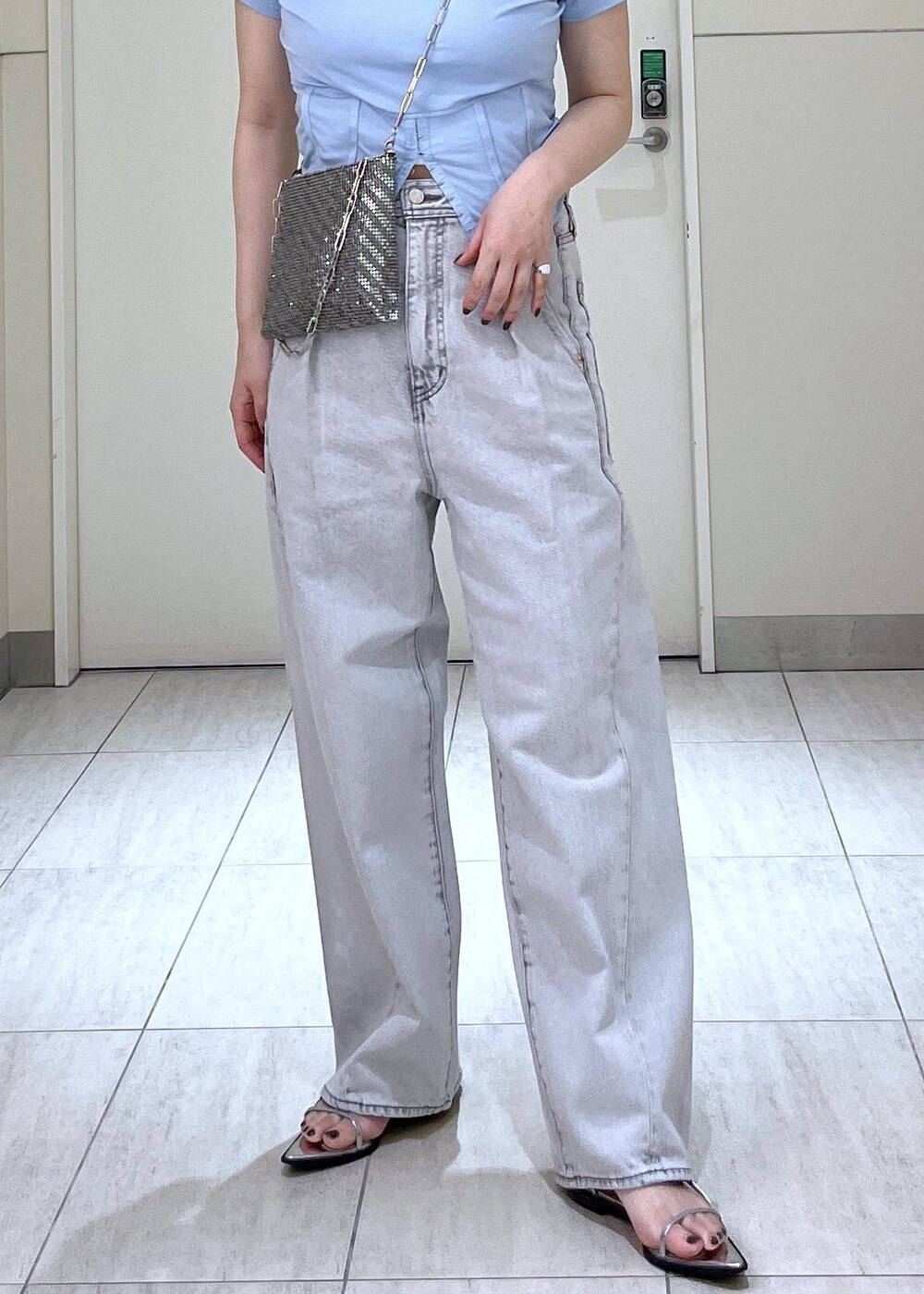 シルバー系のサンダル、ブルー系のTシャツ/カットソー、ブラック系のデニムパンツを着用したレディースの春コーディネートの4枚目の写真