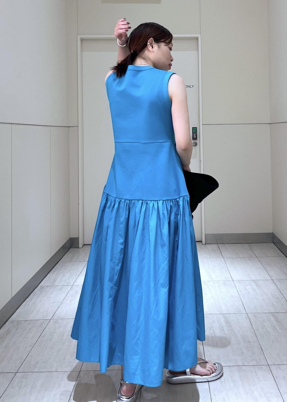 シルバー系のサンダル、ブルー系のワンピース、ブラック系のポーチを着用したレディースの夏コーディネートの7枚目の写真