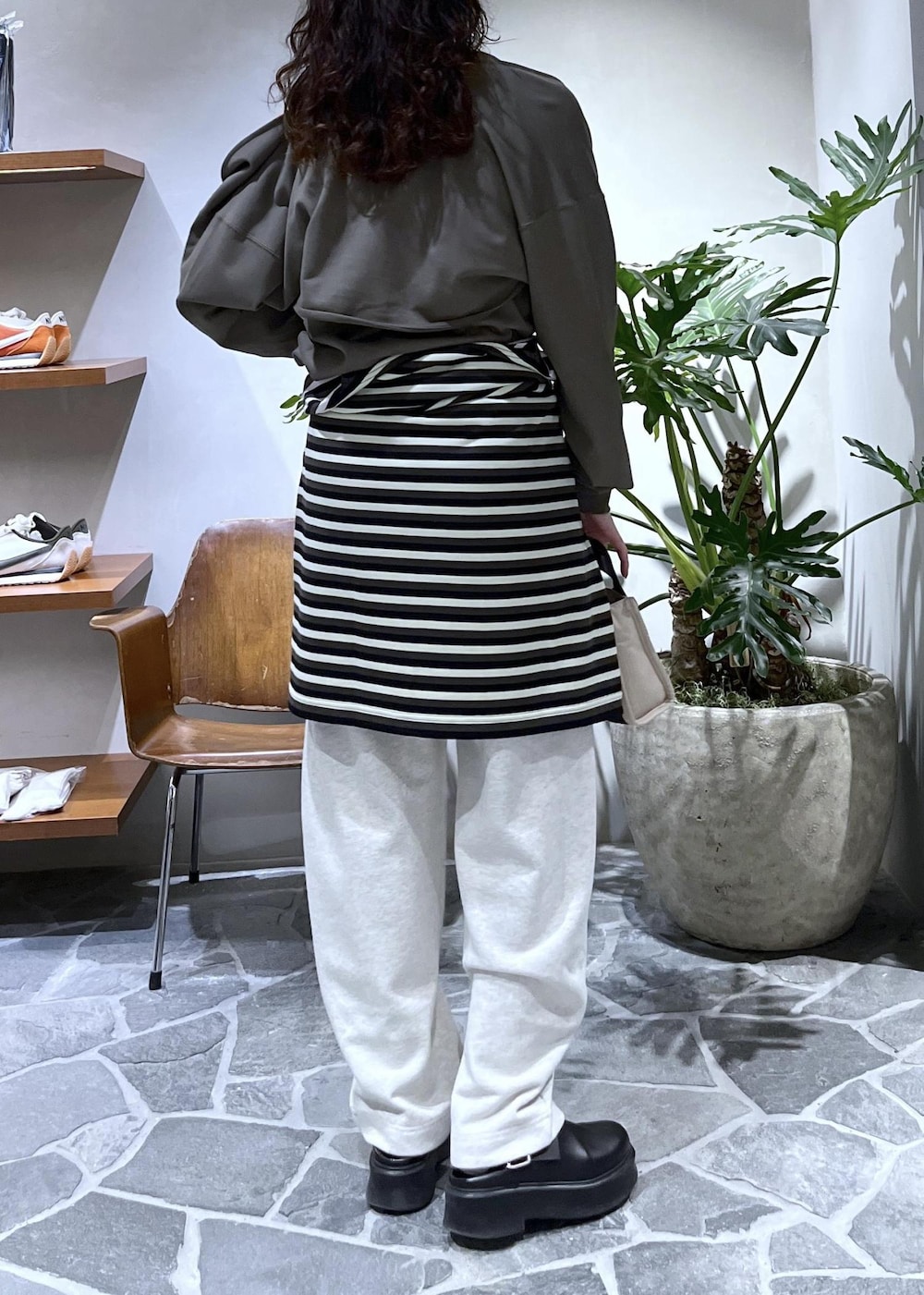 ベージュ系のトートバッグ、ブラック系のサンダル、ピンク系のTシャツ/カットソーを着用したレディースの秋コーディネートの6枚目の写真