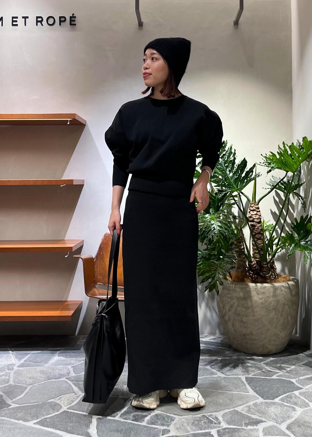 ブラック系のTシャツ/カットソー、ブラック系のスカート、ブラック系のトートバッグを着用したレディースの秋コーディネートの2枚目の写真