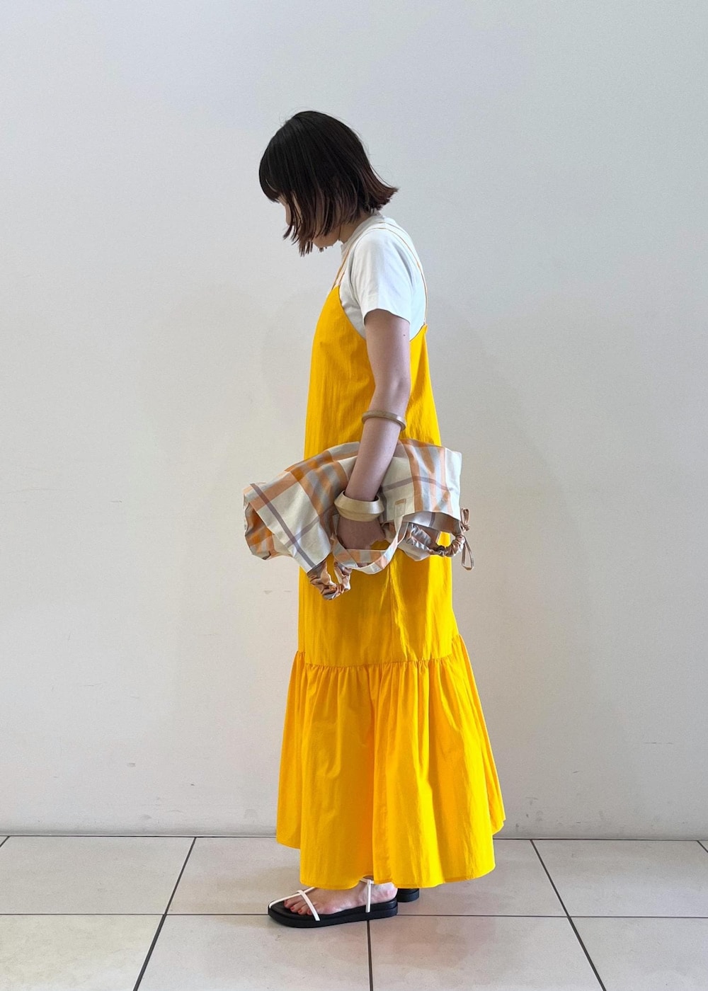 ホワイト系のTシャツ/カットソー、ホワイト系のサンダル、オレンジ系のトートバッグを着用したレディースの夏コーディネートの2枚目の写真