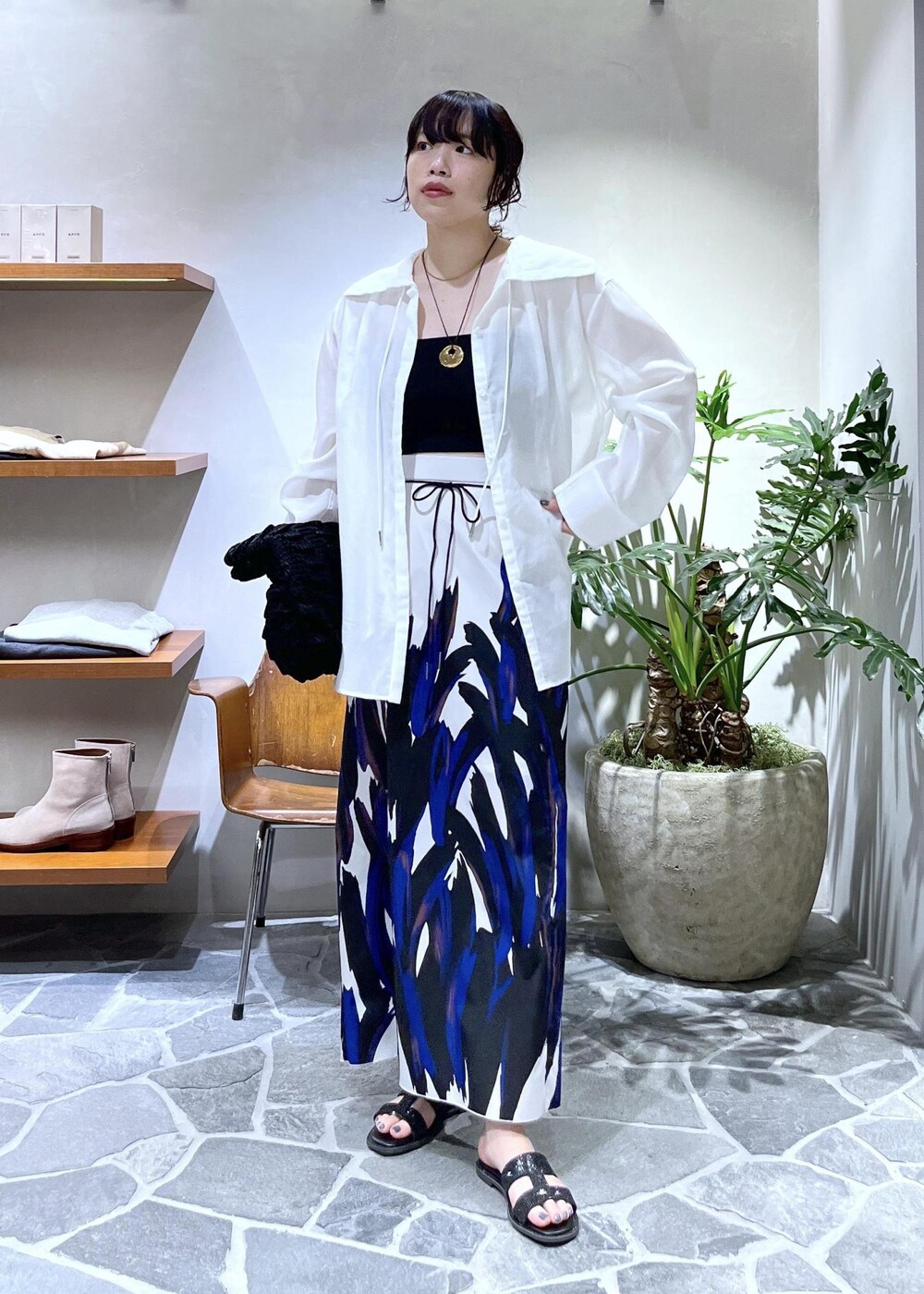 ブラック系のハンドバッグ、ブラック系のサンダル、ホワイト系のシャツ/ブラウスを着用したレディースの春コーディネートの3枚目の写真