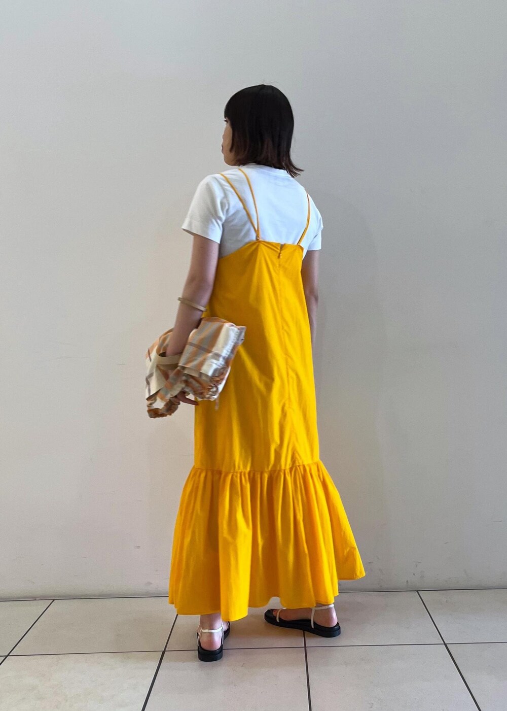 ホワイト系のTシャツ/カットソー、ホワイト系のサンダル、オレンジ系のトートバッグを着用したレディースの夏コーディネートの3枚目の写真