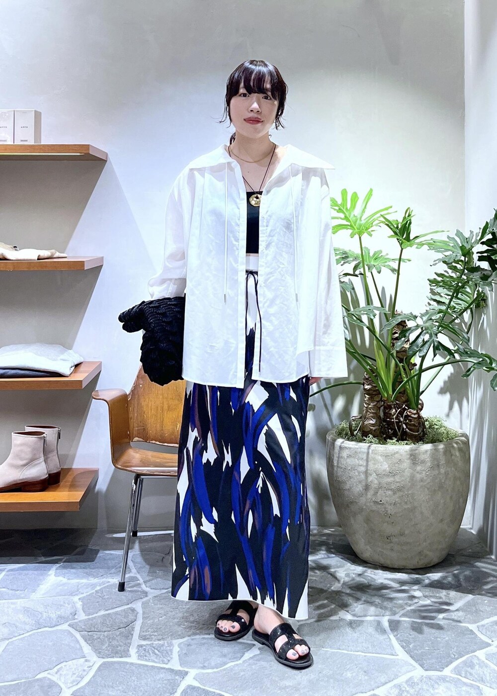 ブラック系のハンドバッグ、ブラック系のサンダル、ホワイト系のシャツ/ブラウスを着用したレディースの春コーディネートの2枚目の写真