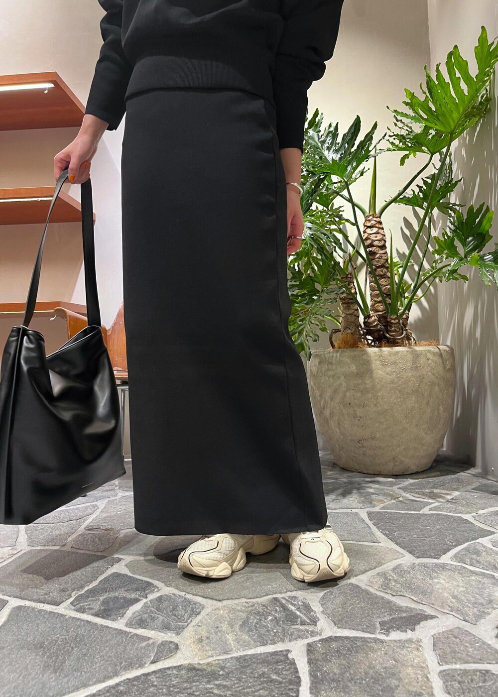 ブラック系のTシャツ/カットソー、ブラック系のスカート、ブラック系のトートバッグを着用したレディースの秋コーディネートの5枚目の写真