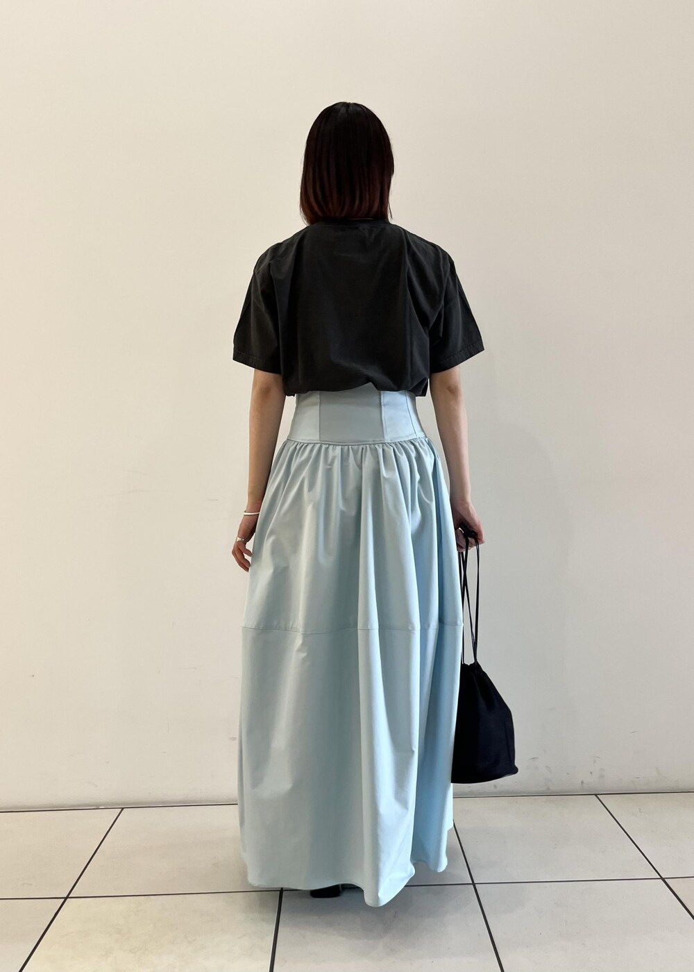 ブルー系のスカート、ブラック系のサンダル、ブラック系のショルダーバッグを着用したレディースの夏コーディネートの3枚目の写真