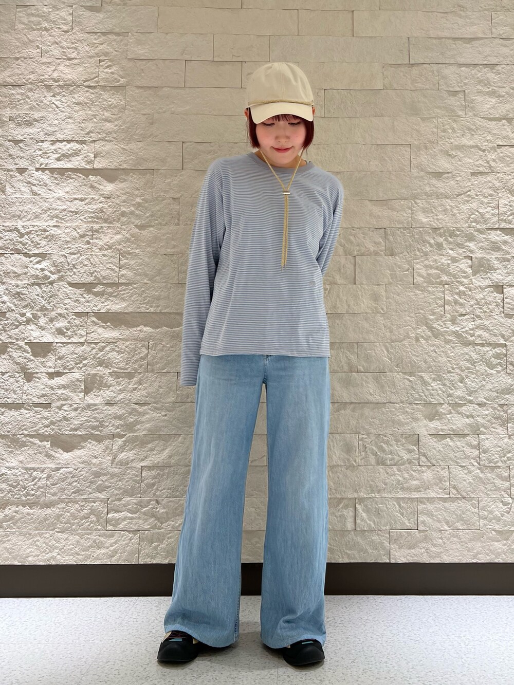 ブルー系のスニーカー、ベージュ系のキャップを着用したレディースの春コーディネートの2枚目の写真