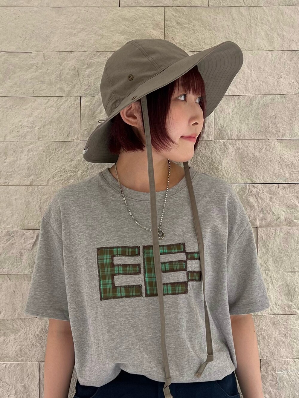 ブラウン系のハットを着用したレディースの夏コーディネートの2枚目の写真