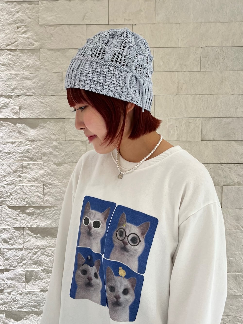 ホワイト系のスウェット、ブルー系のニットキャップ/ビーニーを着用したレディースの冬コーディネートの2枚目の写真