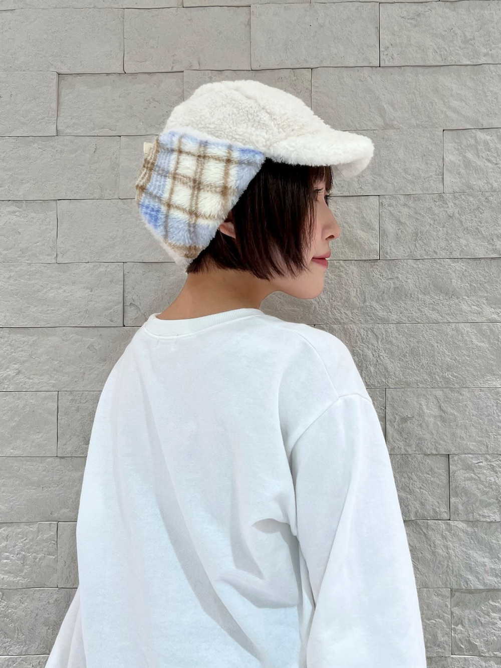 ホワイト系のスウェット、ブラウン系のパンツ、ブルー系のスニーカーを着用したレディースの秋コーディネートの2枚目の写真