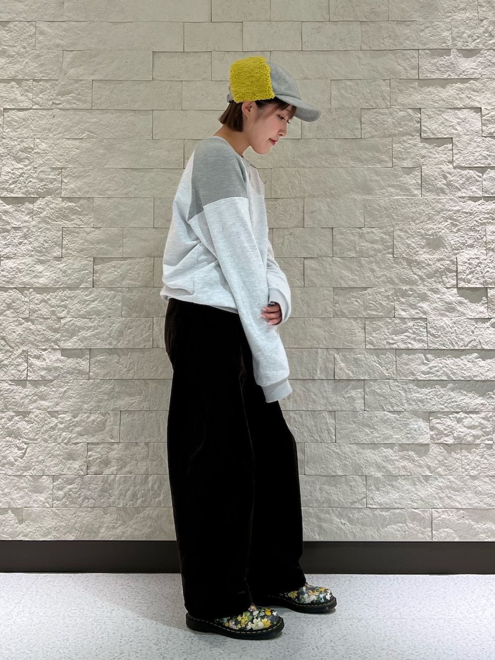 ブラウン系のパンツ、グレー系のキャップを着用したレディースの秋コーディネートの2枚目の写真