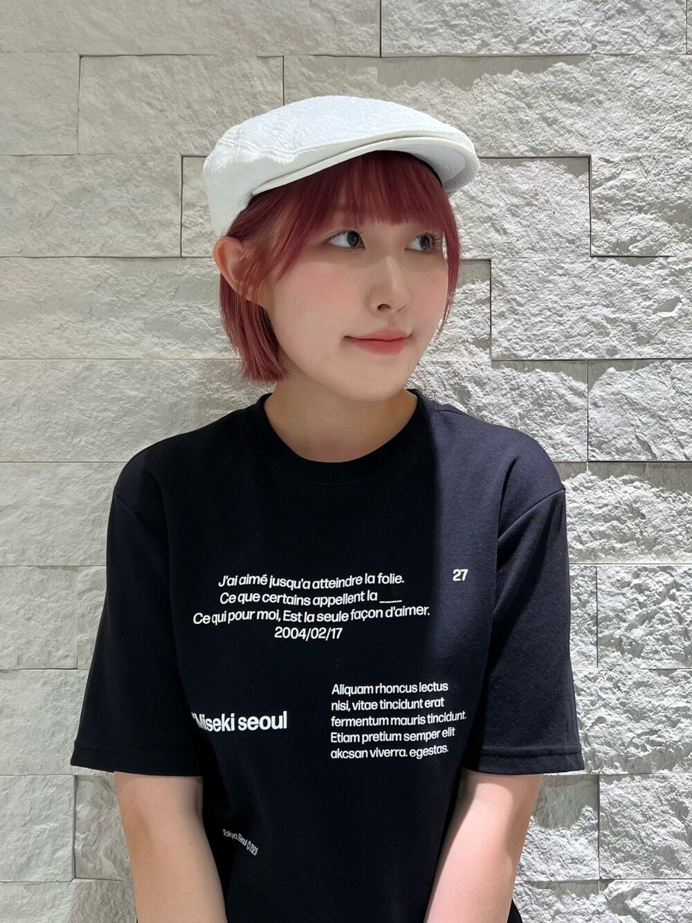 グレー系のスラックス、ブラック系のスニーカー、ホワイト系のハンチング/ベレー帽を着用したレディースの夏コーディネートの3枚目の写真