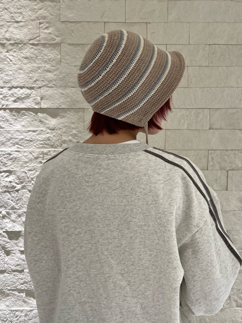 ブルー系のスニーカー、グレー系のスウェット、ブラウン系のハットを着用したレディースの冬コーディネートの3枚目の写真