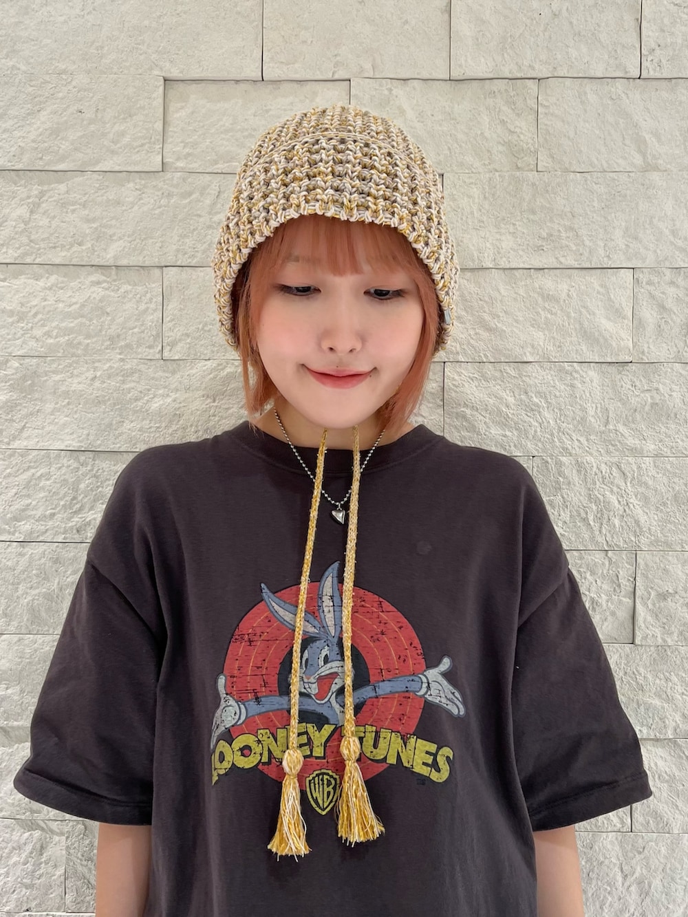 グレー系のスニーカー、イエロー系のハットを着用したレディースの秋コーディネートの2枚目の写真