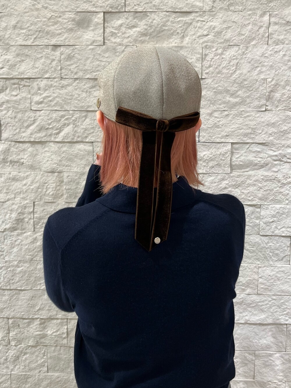 ブルー系のニット/セーター、グレー系のスラックス、ベージュ系のハンドバッグを着用したレディースの秋コーディネートの3枚目の写真