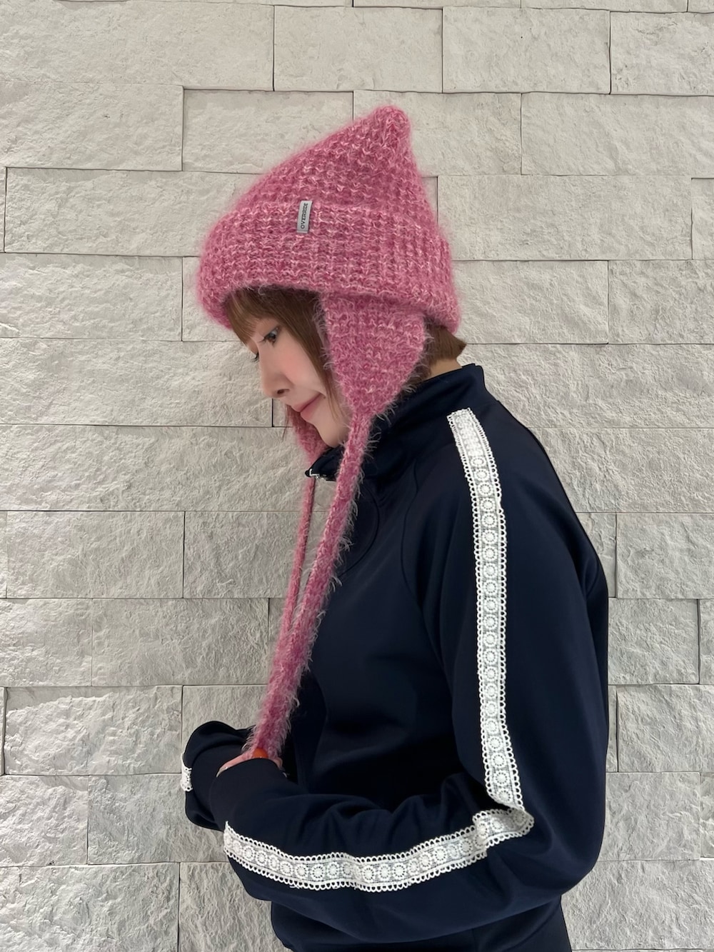 グレー系のスカート、グレー系のスニーカー、ピンク系のニットキャップ/ビーニーを着用したレディースの秋コーディネートの3枚目の写真