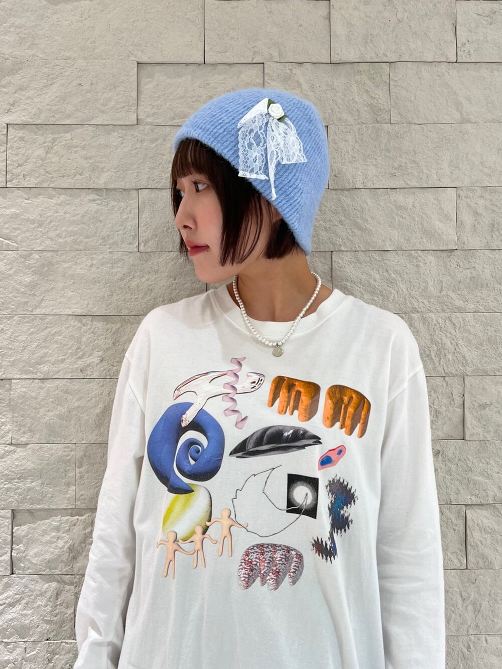 グレー系のスカート、ホワイト系のTシャツ/カットソー、ブルー系のニットキャップ/ビーニーを着用したレディースの秋コーディネートの2枚目の写真