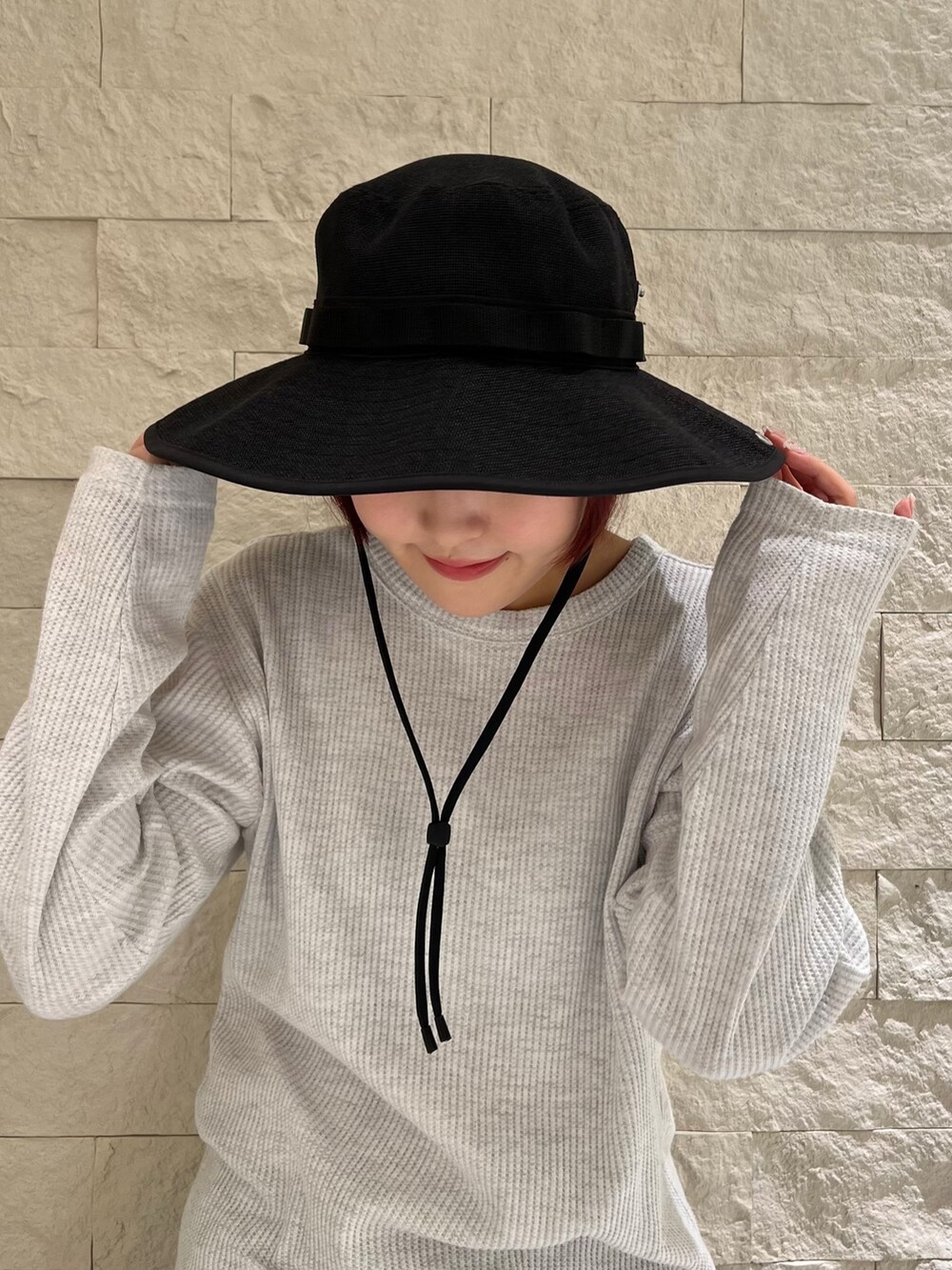 ブラック系のブーツ、ブラック系のハットを着用したレディースの春コーディネートの3枚目の写真