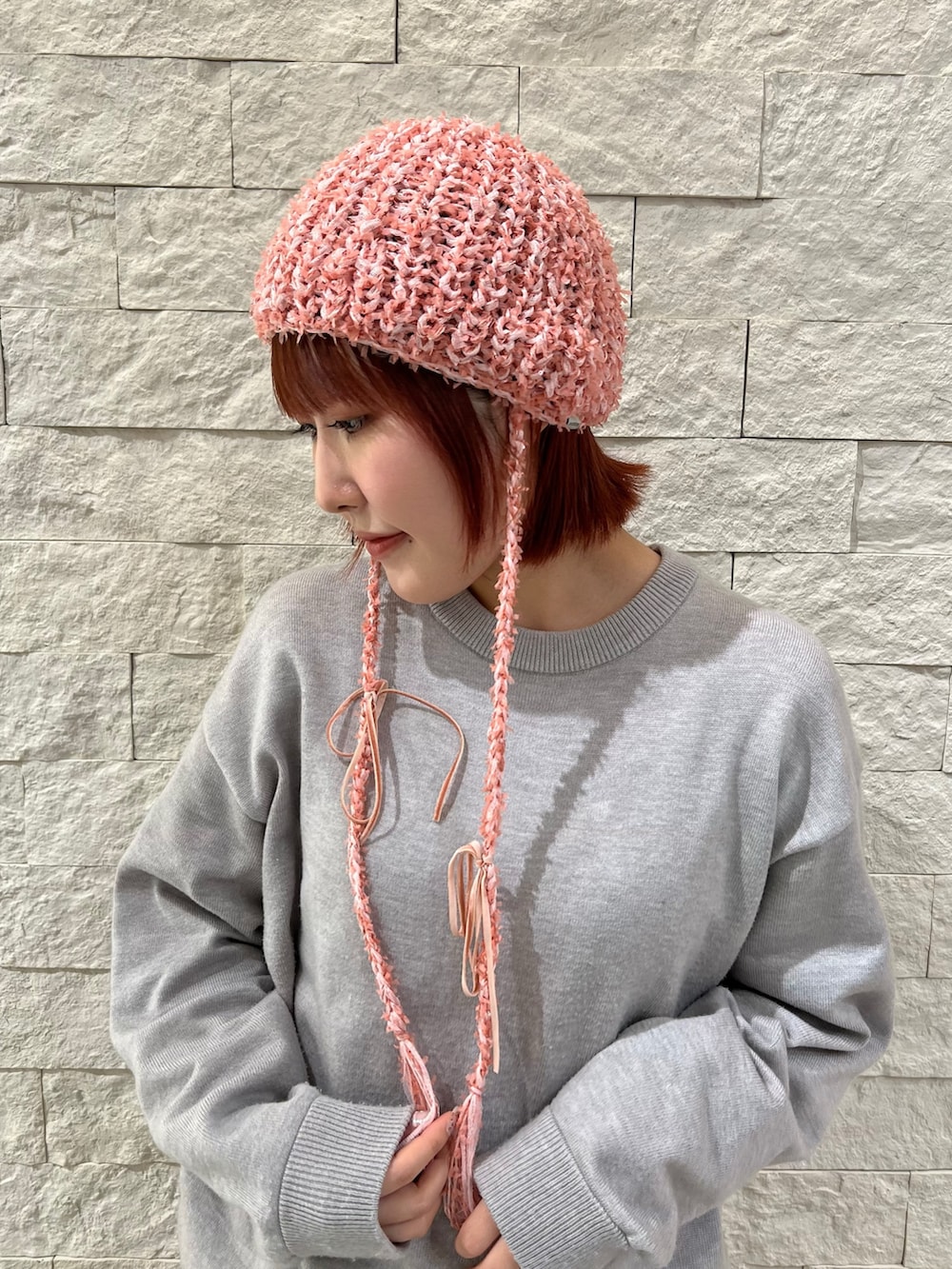 ピンク系のニットキャップ/ビーニーを着用したレディースの春コーディネートの2枚目の写真