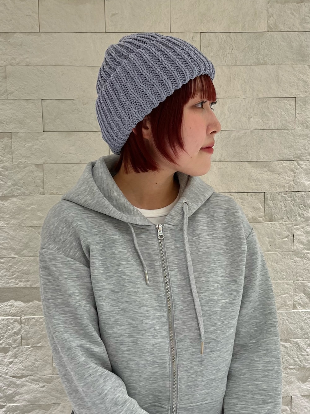 グレー系のスカート、グレー系のパーカー、ブルー系のニットキャップ/ビーニーを着用したレディースの冬コーディネートの3枚目の写真