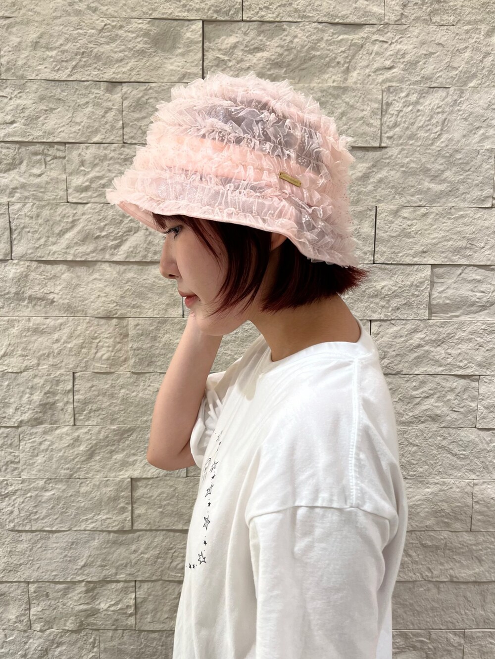 ピンク系のハットを着用したレディースの夏コーディネートの3枚目の写真