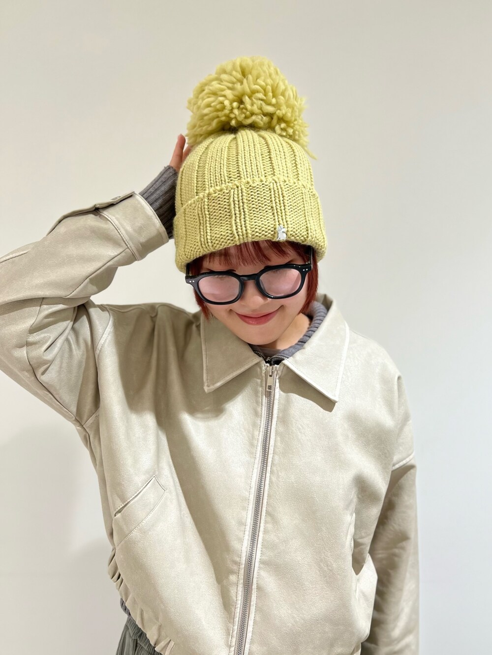 イエロー系のニットキャップ/ビーニーを着用したレディースの冬コーディネートの2枚目の写真