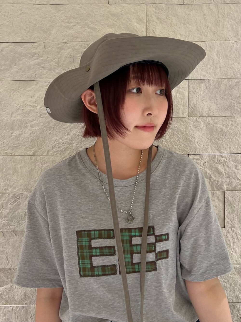 ブラウン系のハットを着用したレディースの夏コーディネートの3枚目の写真